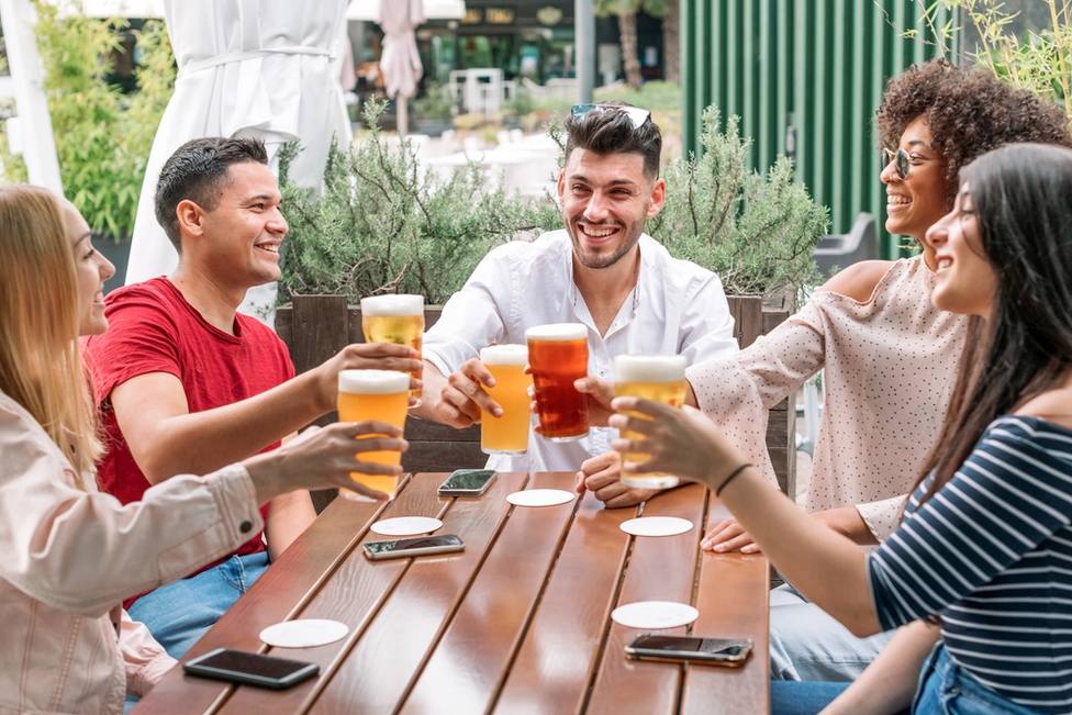 Personas tomando una cerveza en la terraza de un bar