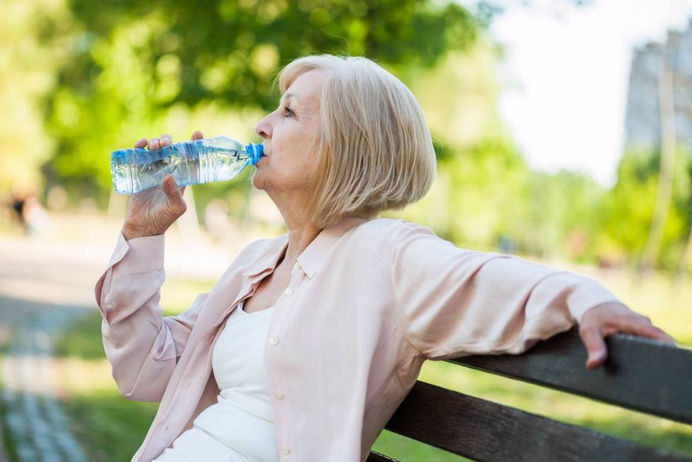 Mujer bebiendo agua en un parque