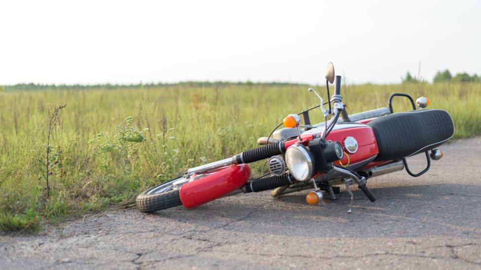Foto de archivo de una moto caída sobre el asfalto