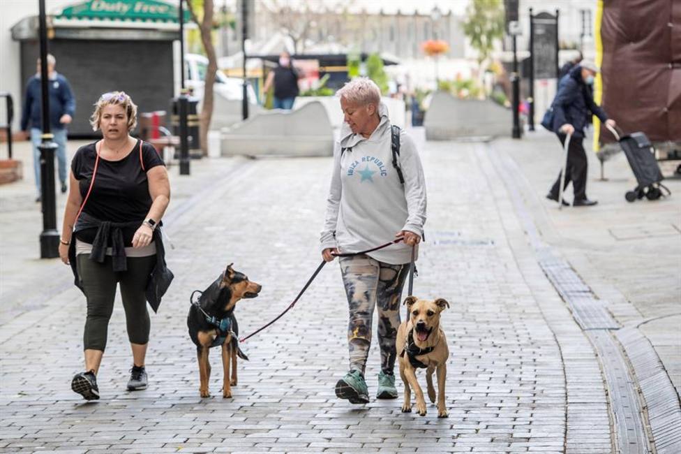 Dos mujeres pasean a sus perros sin mascarilla por las calles de Gibraltar este domingo