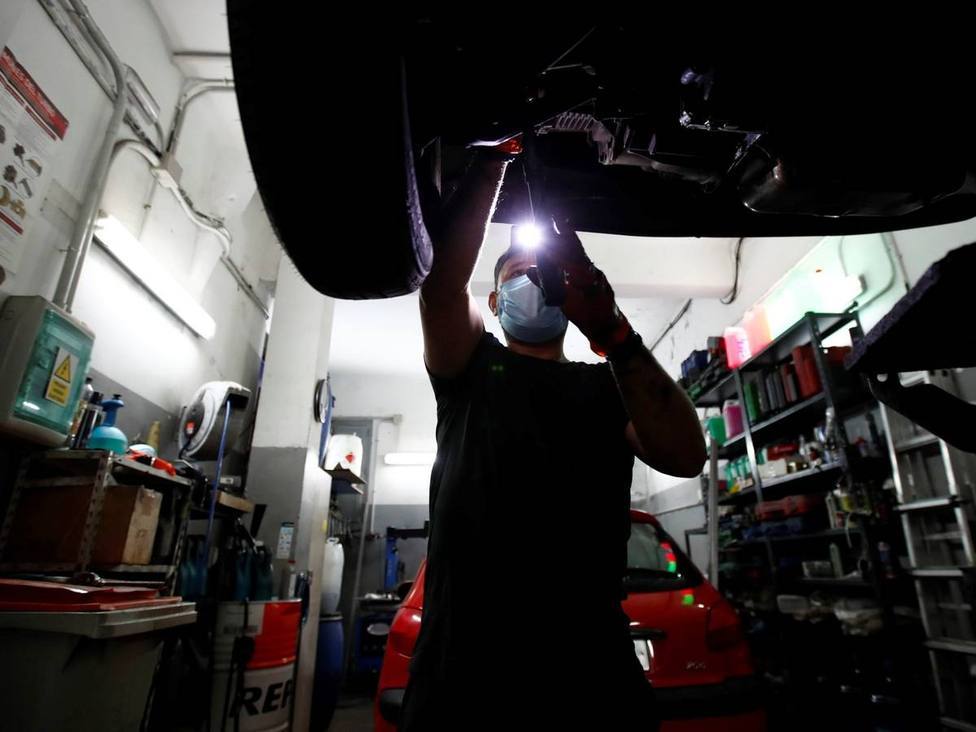 Un mecánico revisa un coche en un taller