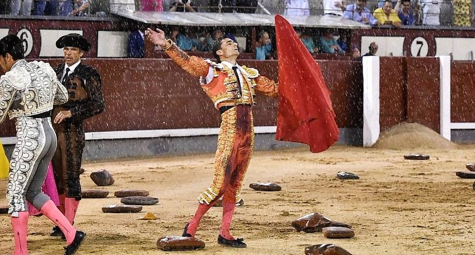 Paco Ureña tras caer el quinto toro en un mar de almohadillas entre la lluvia