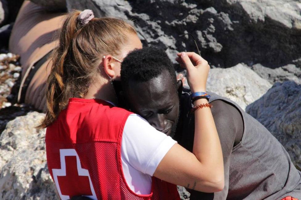 Una de las imágenes en la que se puede ver a la joven abrazando a uno de los migrantes