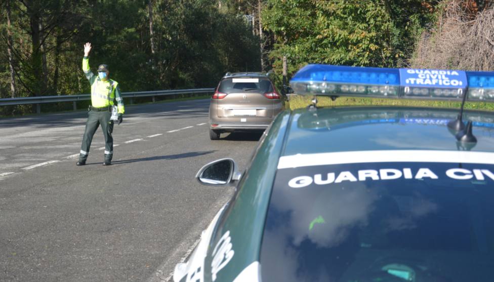Un guardia civil de tráfico le da el alto a un coche en una carretera de Lugo