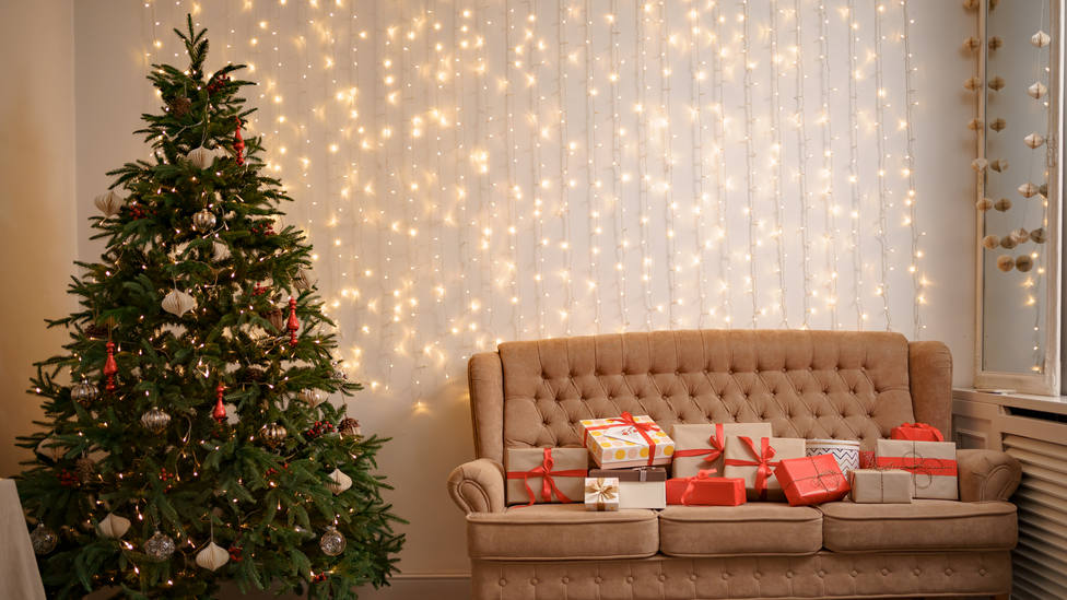 Christmas living room with a christmas tree and presents on the sofa