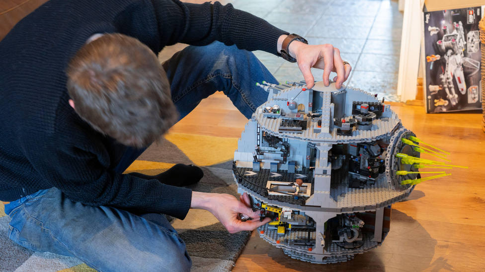 Un hombre construyendo una maqueta de Lego de Star Wars
